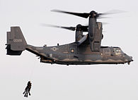 Dos buzos SEAL siendo izados por un convertiplano CV-22 Osprey.